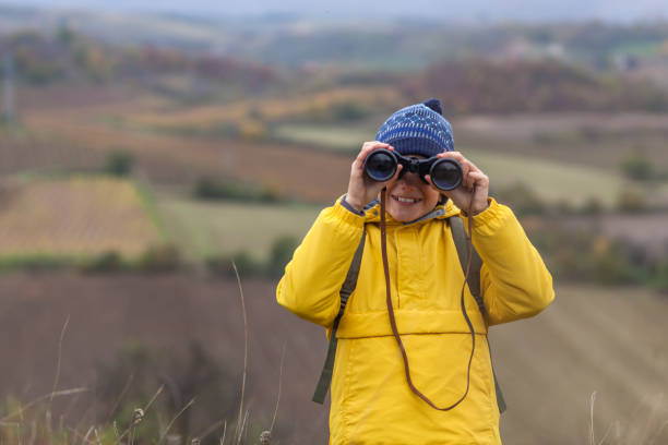 istock Happy boy looking through binoculars in nature. 1288673617