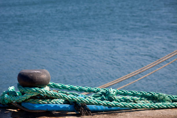 istock Harbor mooring post, thick ropes, sea background. 1288677987