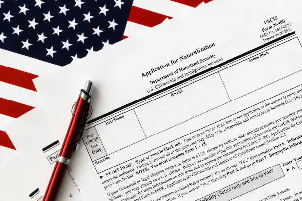 close-up of n-400 form. application for naturalization topview, on a background of United States flag.