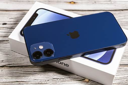 Saint Petersburg, Russia - November 28, 2020: Apple iPhone 12 mini blue with box on wooden background.