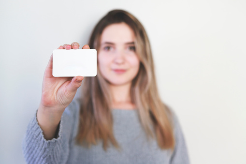 Woman holding blank business card. White Paper Card for Mockup