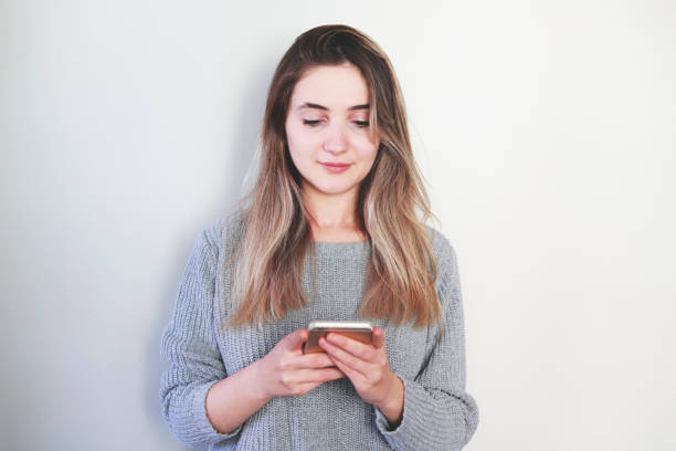 istock Young woman over isolated gray background sending a message with the mobile 1288682642