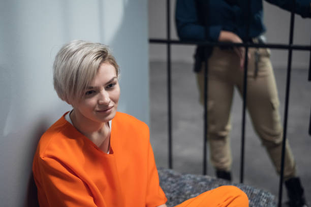 Portrait of a young prisoner in a uniform in a prison cell stock photo