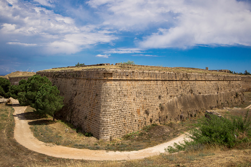 Ruins of the ancient wall, Cyprus, Famagusta. Historical architecture, tourist place. Clear blue sky with white clouds.
