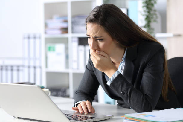 istock Sad executive reading bad news on laptop at the office 1288685300
