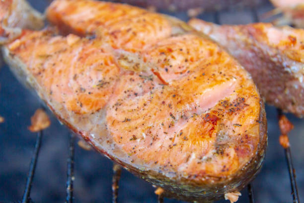 istock Large fish steaks fresh trout fried in spices on the grill 1288686525