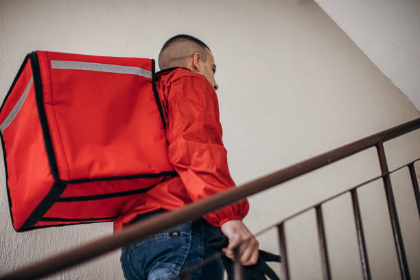 istock Food delivery man inside of a building 1288688587