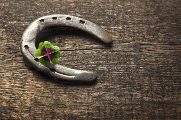 istock Horseshoe with lucky clover on a wooden background 1288688941