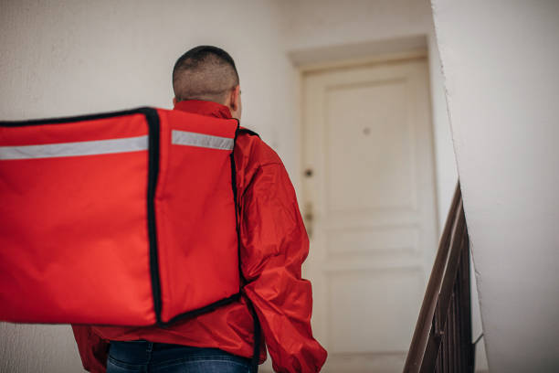istock Food delivery man inside of a building 1288689615