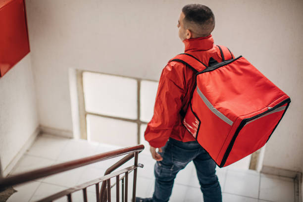 istock Food delivery man inside of a building 1288689637