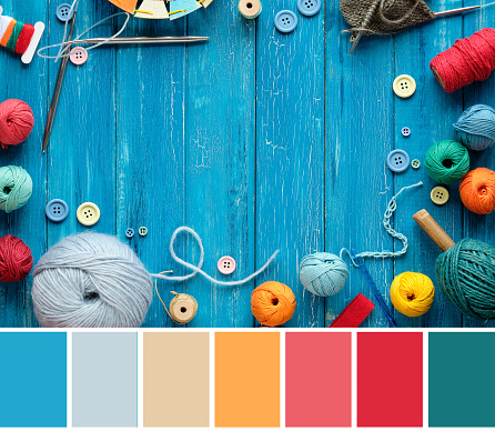 Color matching palette from close-up image of wool bundles, yarn balls, buttons and cord. Latch and knitting needles on turquoise wood boards.