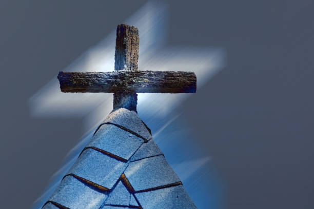Photo illustration of a rugged, wooden cross at the apex of a church steeple.