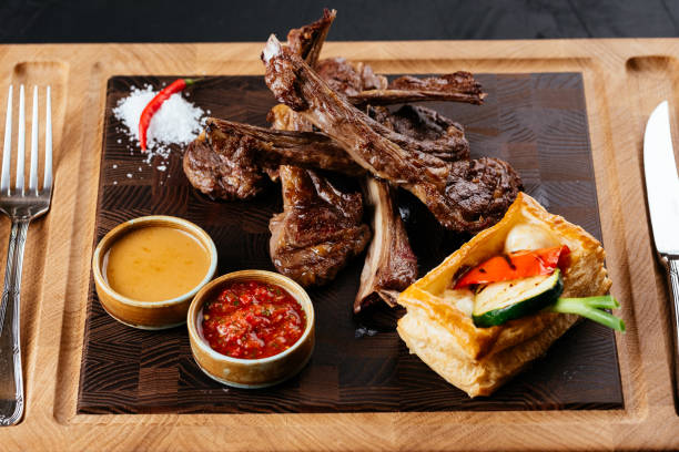 istock grilled lamb rack with vegetables and sauce on a black backgroun 1288692150
