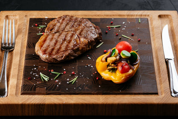 istock marbled beef steak with vegetables and sauce on a black backgrou 1288692168