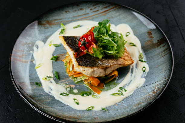istock grilled cod fillet with vegetables and sauce on a black backgrou 1288692292