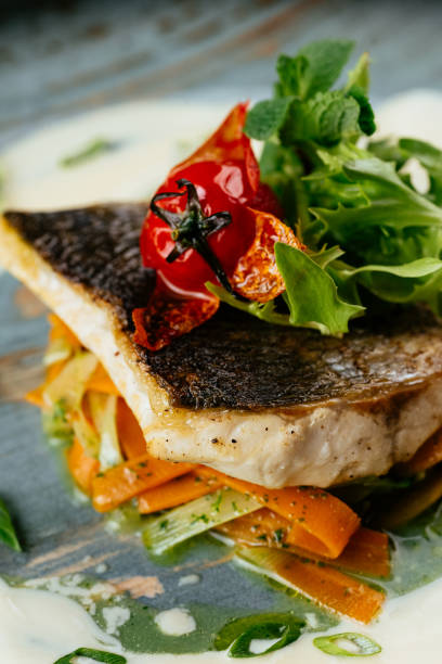istock grilled cod fillet with vegetables and sauce on a black backgrou 1288692303