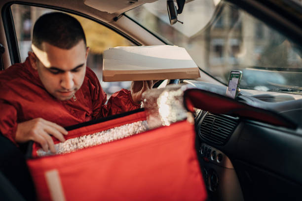 istock Pizza delivery man in a car 1288692833