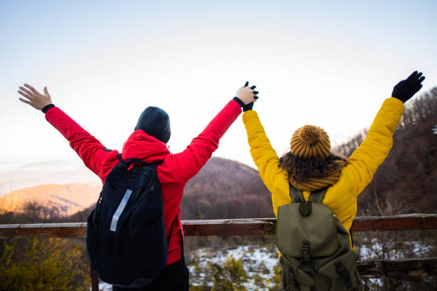 istock Happy young couple with raised arms enjoys in view 1288694112
