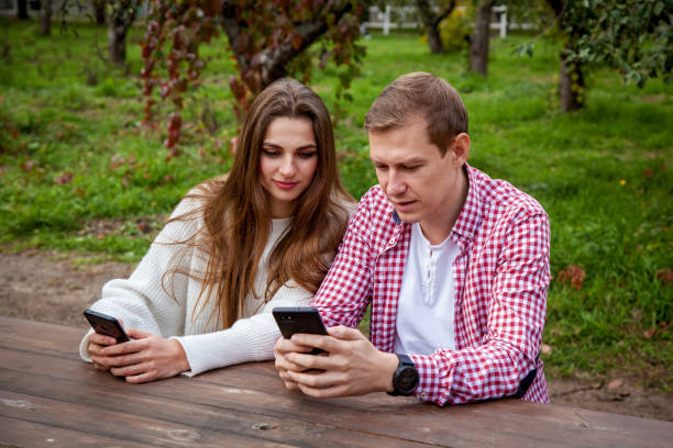 istock guy with girl with gadgets in the park 1288702295