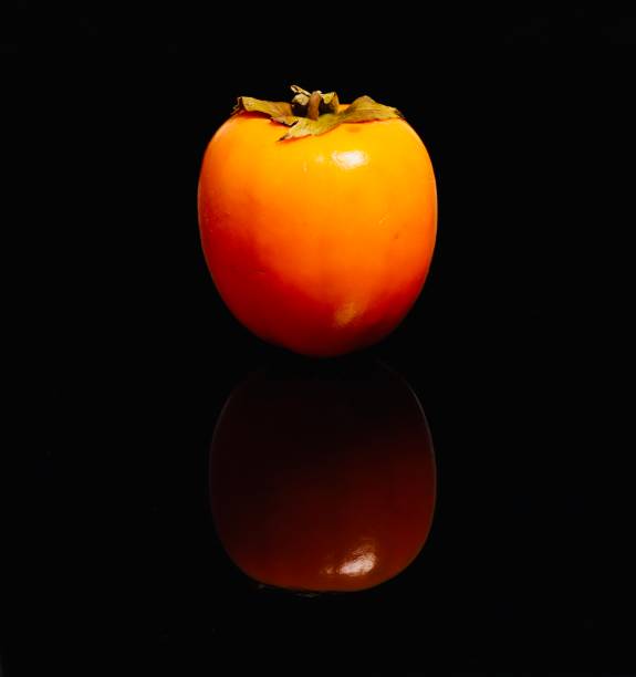istock Persimmon kaki fruit on black background close up 1288704320