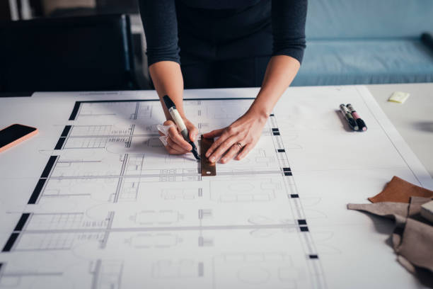 istock Hands of an Anonymous Woman Architect Making Changes on a Printed Project at her Studio 1288707164