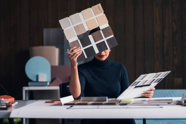 Interior Design Project Development: a Woman Architect Going Through a Flooring Sample Palette at her Studio Female interior designer using a sample palette at her modern office. building floor plan stock pictures, royalty-free photos & images