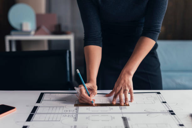 istock Hands of an Anonymous Woman Architect Making Changes on a Printed Project at her Studio 1288707211