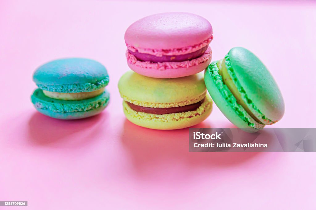 Manis almond warna-warni merah muda kuning macaron hijau atau macaroon dessert cake terisolasi pada latar belakang pastel merah muda trendi. Kue manis Perancis. Konsep toko roti makanan minimal. Tampilan atas berbaring datar, ruang salin - Bebas Royalti Adiboga Foto Stok Manis almond warna-warni merah muda kuning macaron hijau atau macaroon dessert cake terisolasi pada latar belakang pastel merah muda trendi. Kue manis Perancis. Konsep toko roti makanan minimal. Tampilan atas berbaring datar, ruang salin - Bebas Royalti Adiboga Foto Stok