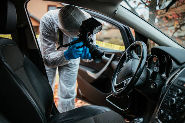 Forensic Investigation Experienced inspector or investigator in protective suite collecting evidence and taking photos about crime scene in a car. dead person photos stock pictures, royalty-free photos & images