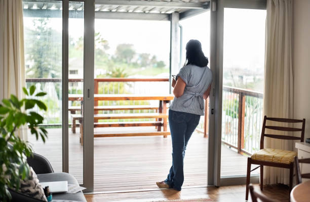 Woman standing at balcony door