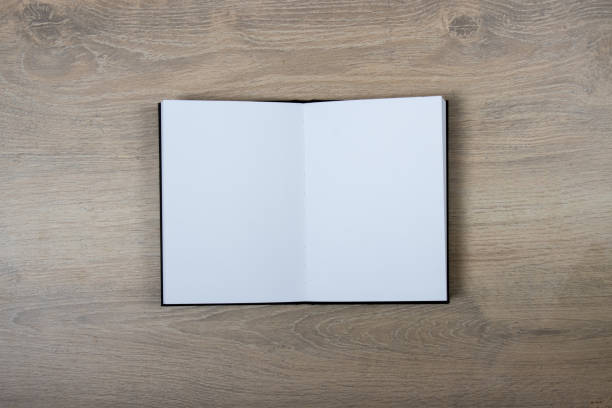 istock Open sketchbook with blank pages on wood background 1288715750