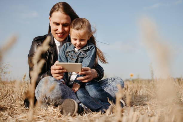 istock Father and daughter playing games with cell phone 1288716078