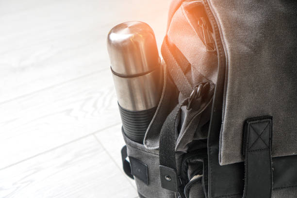 istock Preparing for hiking adventure. Outing into nature concept. Background with backpack and thermos standing on the white wooden floor. 1288717158