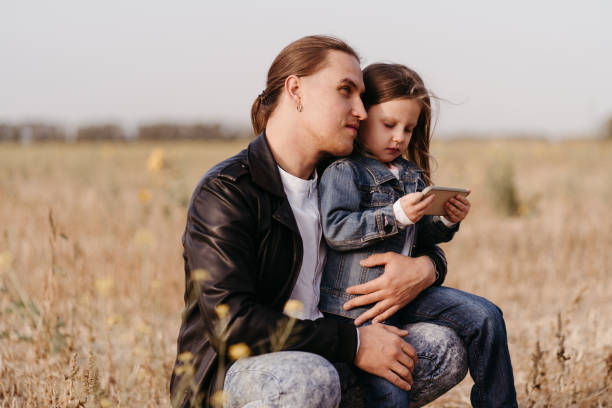istock Father and daughter playing games with cell phone 1288721077