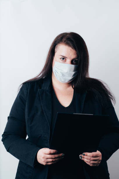 istock Business woman in face mask holding folder 1288721158
