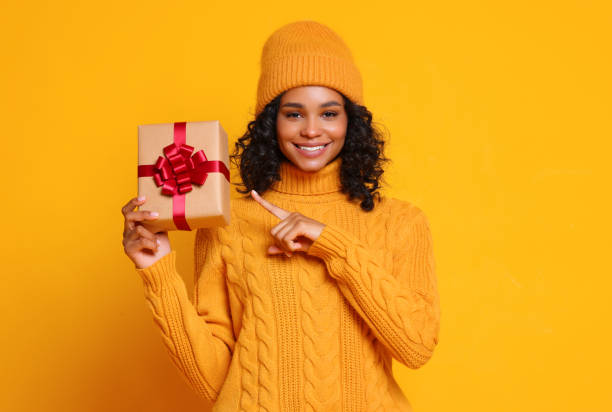 istock Happy ethnic female showing gift 1288723333