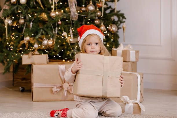 istock Child in Santa hat with Christmas gift 1288724126