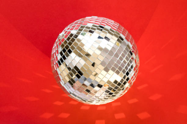 istock Large disco ball on a red background with highlights and reflection. 1288726378