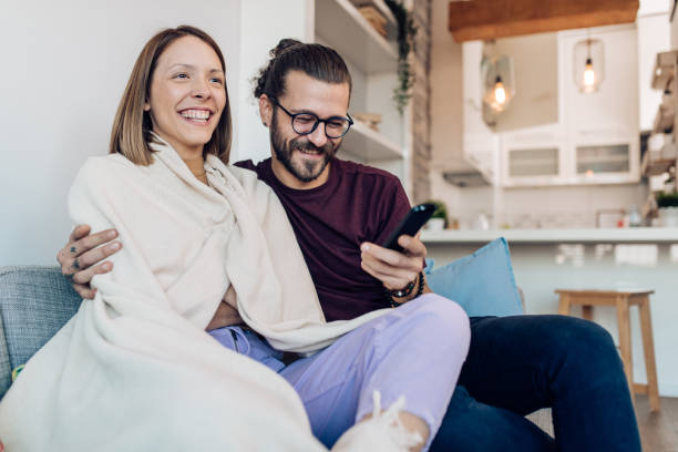 istock Young couple watching TV at home and having fun 1288728604