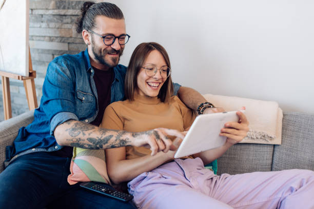 istock Young couple relaxing on the sofa and using digital tablet together 1288728627