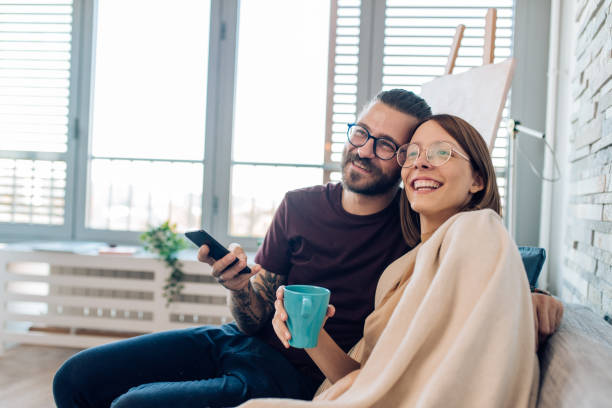 istock Young couple enjoying at home, watching TV and bonding 1288728647