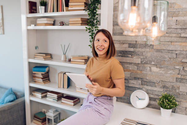 Young woman adjusting a smart house system
