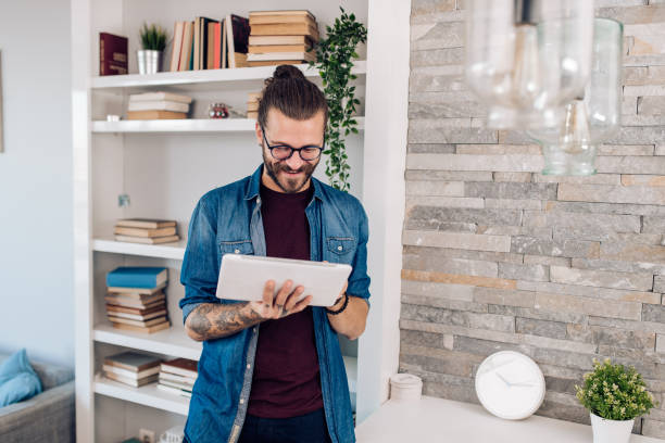 istock Portrait of a young man with tablet turning on a smart home system 1288728673