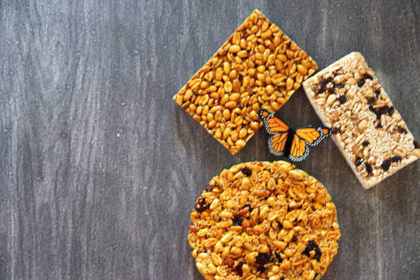 alegrias y palanquetas, mexican amaranth and seed candies with monarch butterfly on gray vintage wooden background the alegrias y palanquetas, mexican amaranth and seed candies with monarch butterfly on gray vintage wooden background candy mexican culture mexican cuisine peanut stock pictures, royalty-free photos & images