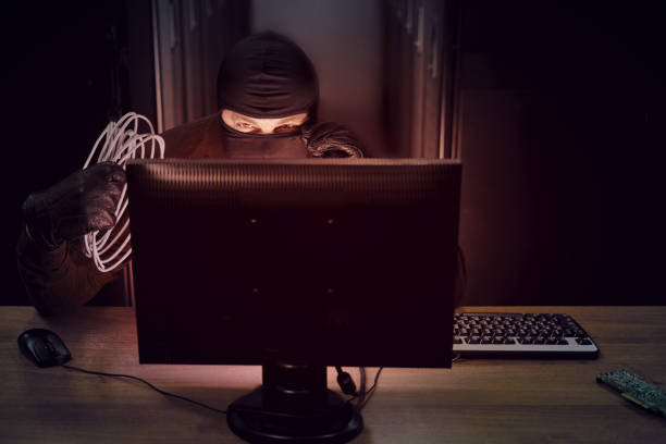 istock A hacker in a black mask with wires in his hand in a server room. Concept of data security problems and network hacking 1288731691