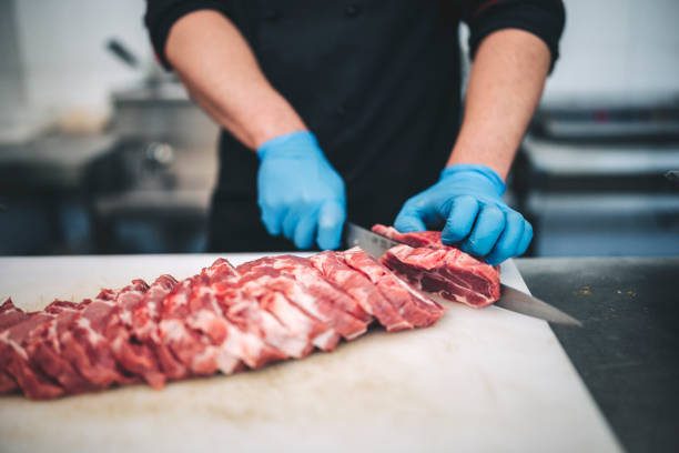 istock Male butcher cut raw meat with sharp knife in restaurants kitchen 1288731896