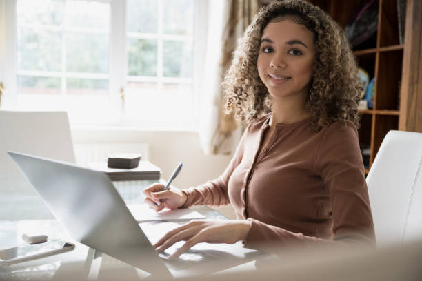 istock Portrait of mixed race high school student working at home 1288732247