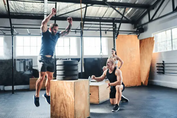 Shot of a man doing box jumps at the gym