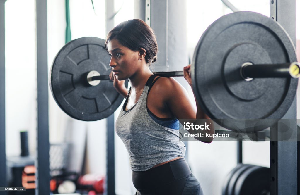 You are strong, strong is you! Cropped shot of a young woman working out with a barbell at the gym Exercising Stock Photo