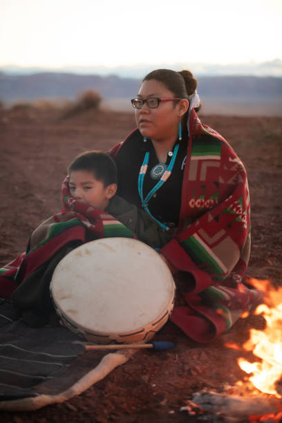 mulher navajo e irmão zinho aquecendo na fogueira no deserto do arizona - monument valley - indian culture child little girls indigenous culture - fotografias e filmes do acervo